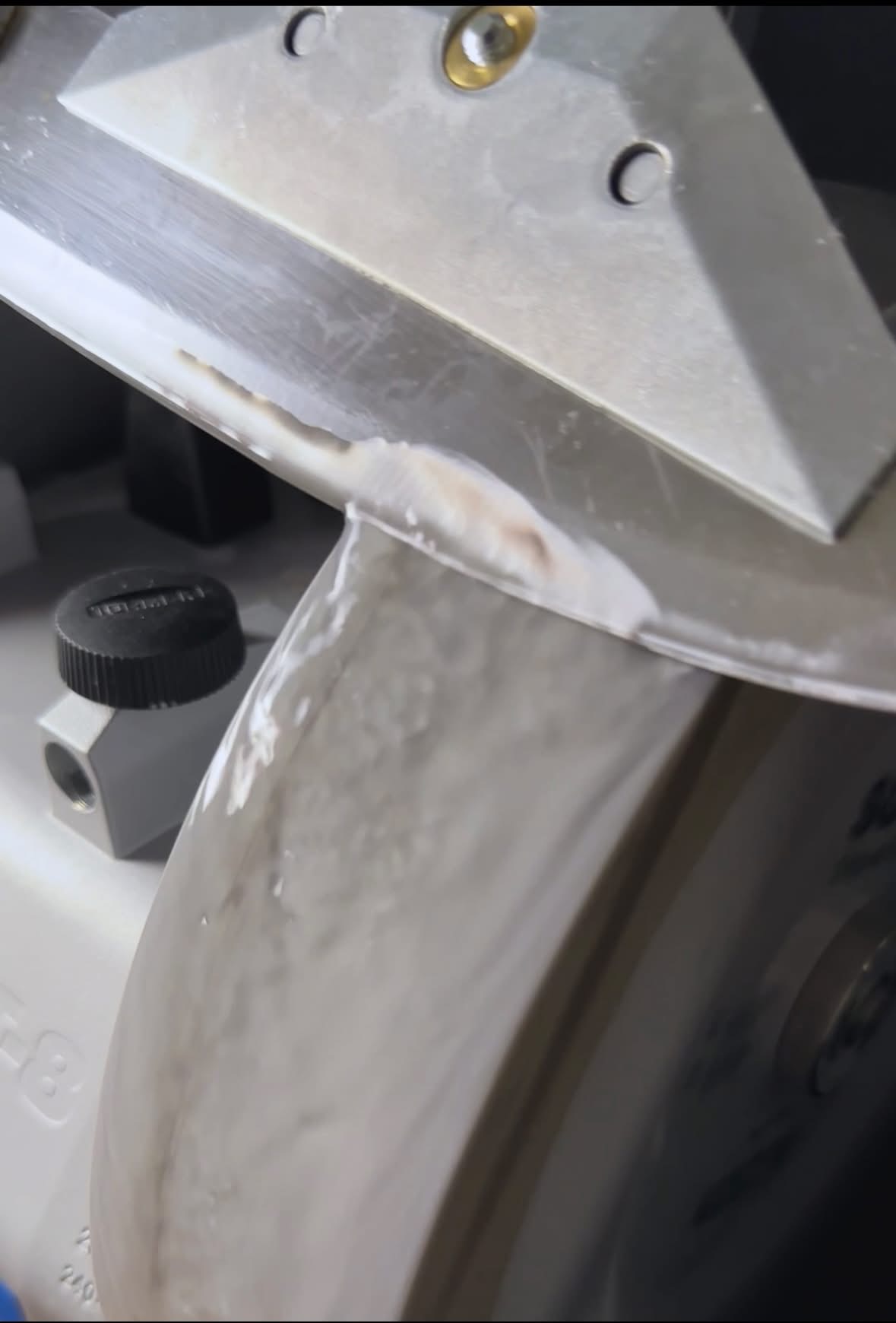 Gros plan de l'eau qui ruisselle sur la meule Tormek pendant l'affûtage