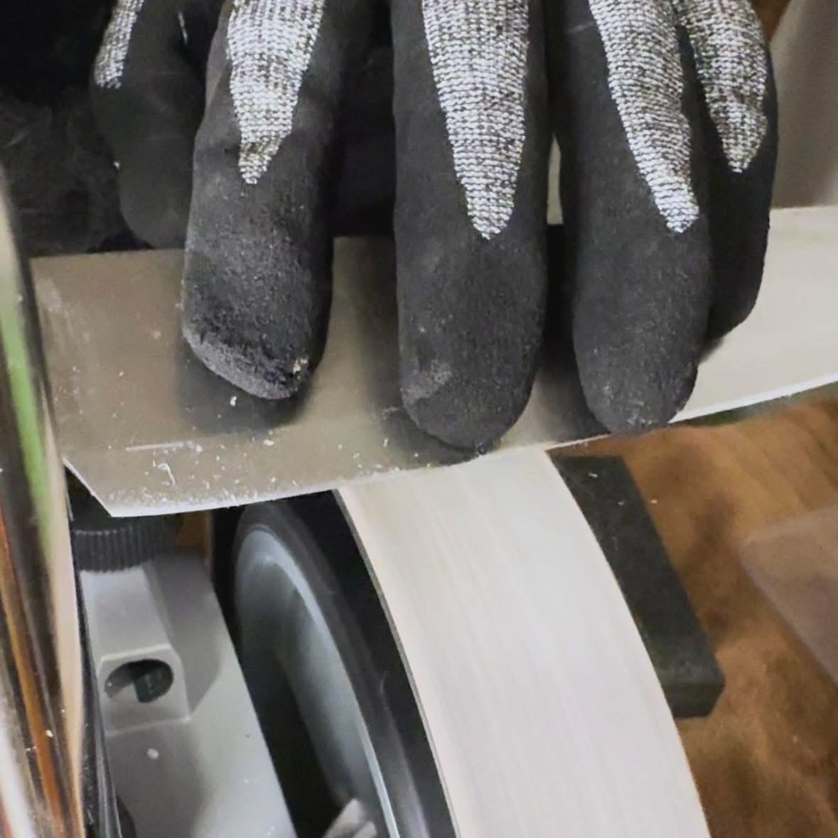 Geste d'affûtage avec gants de protection sur la meule Tormek